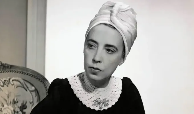 Vogue-1940-Designer-Elsa-Schiaparelli-wearing-black-silk-dress-of-her-own-design-and-a-turban