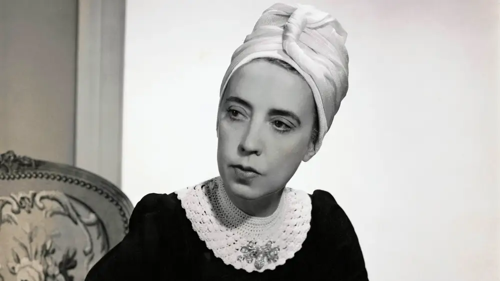 Vogue-1940-Designer-Elsa-Schiaparelli-wearing-black-silk-dress-of-her-own-design-and-a-turban